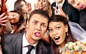 Lustiges Brautpaar mit Hochzeitsgästen